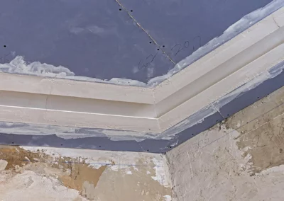 Zoom sur la pose des angles pour un faux-plafond dans un bâtiment professionel